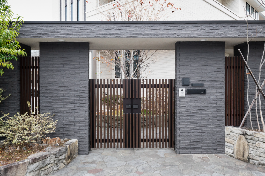 Desain pagar rumah modern dengan kombinasi dinding batu dan logam