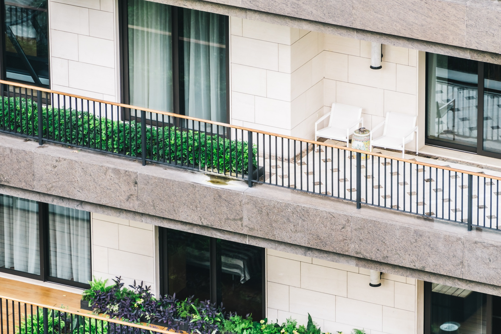 Balkon rumah lantai dua dengan railing besi minimalis berwarna hitam