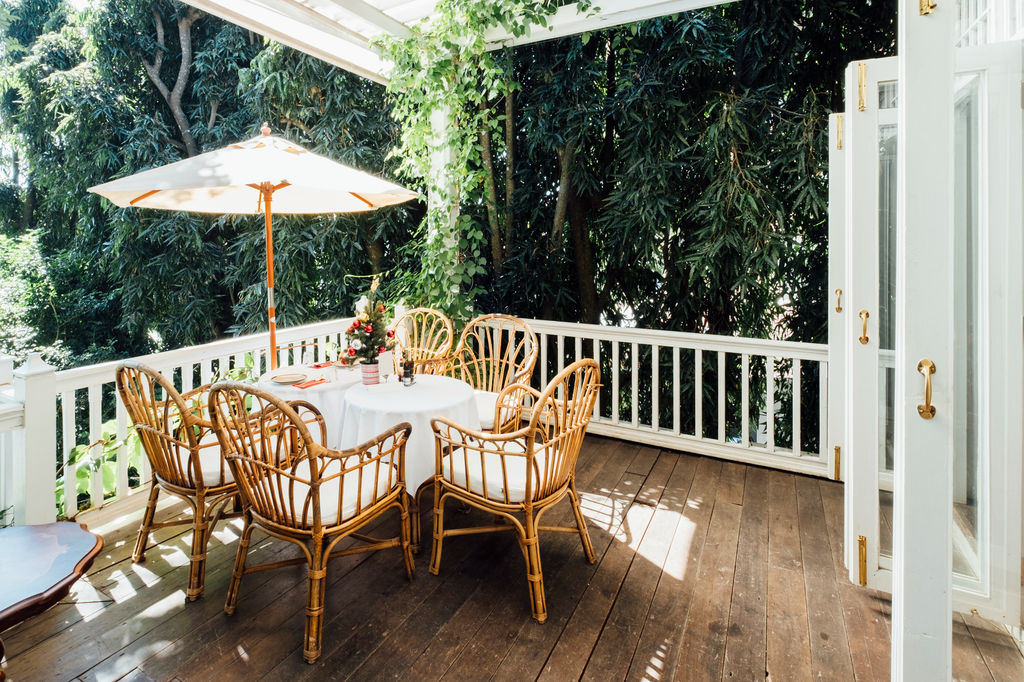 Balkon rumah minimalis dengan lantai dan furnitur bernuansa kayu alami