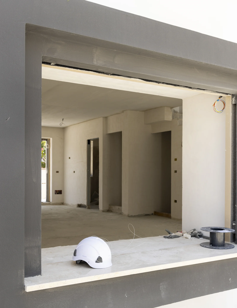 Struktur dinding rumah dengan bukaan jendela dan elemen pendukung di sekitar kusen sebelum proses pemasangan.