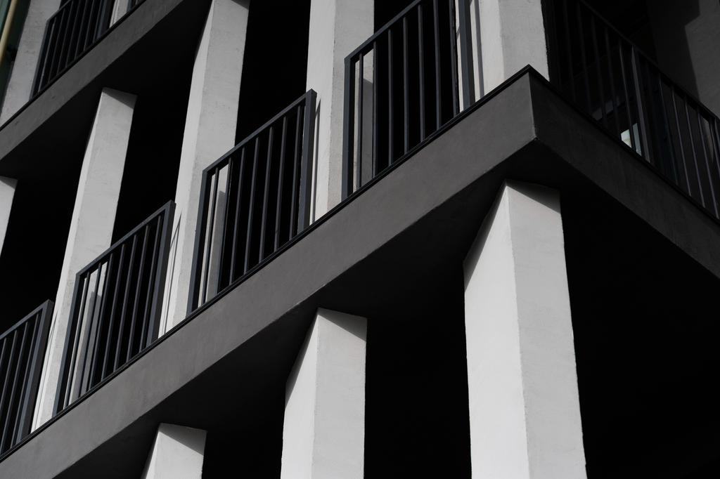 Desain pagar balkon aluminium hitam minimalis dengan pola geometris sederhana pada rumah modern.