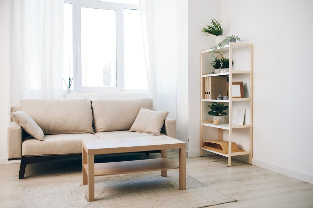 Desain ruang keluarga minimalis modern dengan sofa nyaman, warna netral, pencahayaan alami, dan penataan furnitur sederhana.