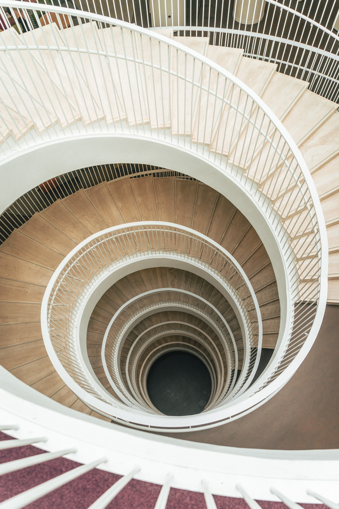 Tangga spiral minimalis berbahan logam dengan desain melingkar pada interior rumah modern