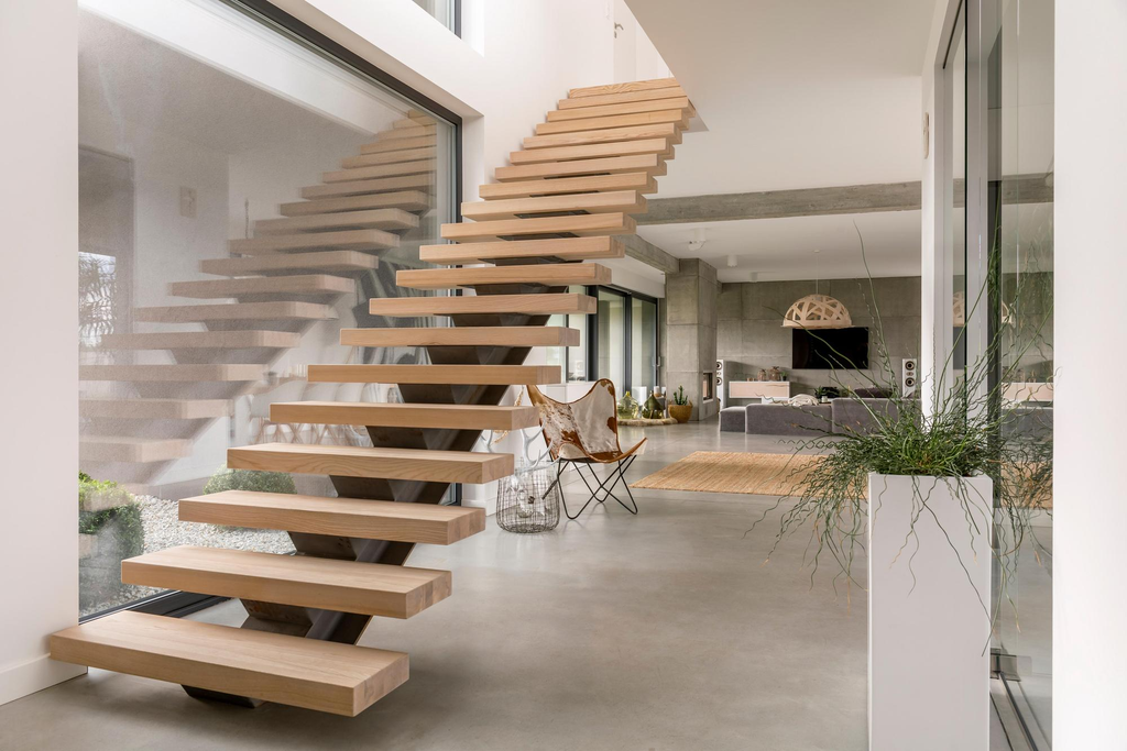 Desain tangga melayang modern dengan anak tangga kayu dan struktur penopang tersembunyi pada rumah minimalis